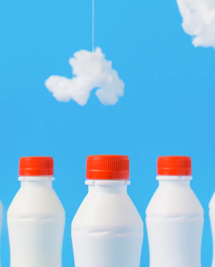 white bottles with orange caps, on a blue background with white clouds imitating a sky.